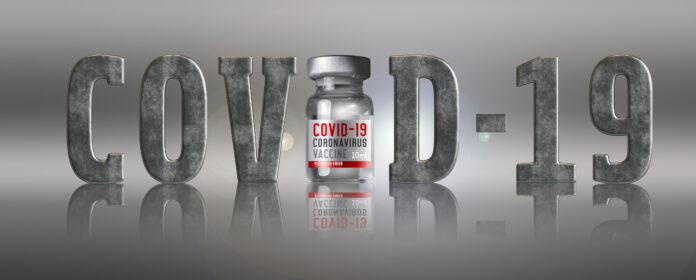 Word Covid-19 and bottle with Coronavirus vaccine